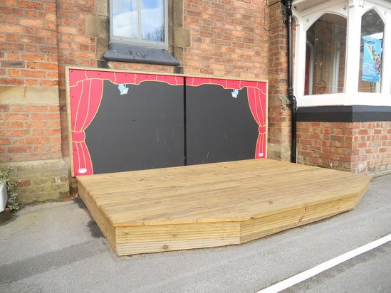 Outdoor timber play stage with backdrop