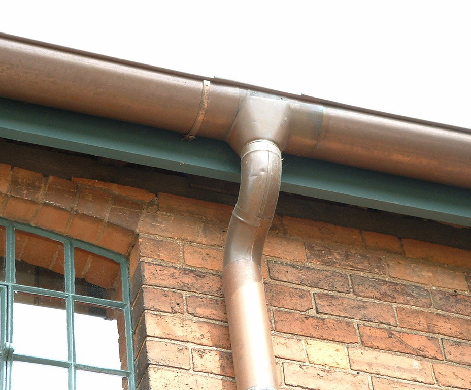 Aged round copper gutter and downpipe, antiques house Metal Gutta