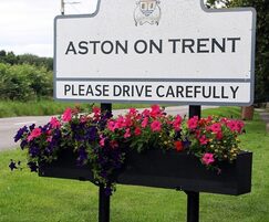 Town welcome sign with planter