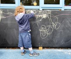 Child expressing creativity on chalk activity board